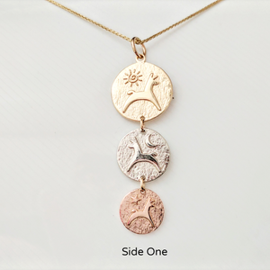 Side 1 of the Alpaca or Llama Reversible Tri-Coin Drop Pendant -The Largest top coin is 14K Yellow Gold with a pronking animal and sun accent, the middle coin is 14K White Gold with a pronking animal and a moon accent, the smallest coin is 14K Rose Gold with a pronking animal and a heart accent